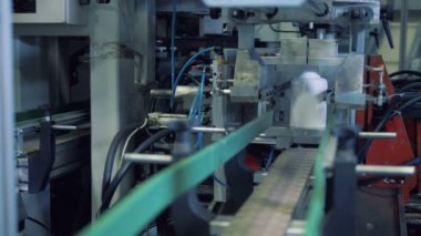 Alt kısmında plastik kaplar otomatik bir mekanizma ile kesiliyor
