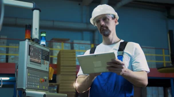 Ingeniero masculino con una tableta está trabajando al lado del panel de potencia — Vídeos de Stock
