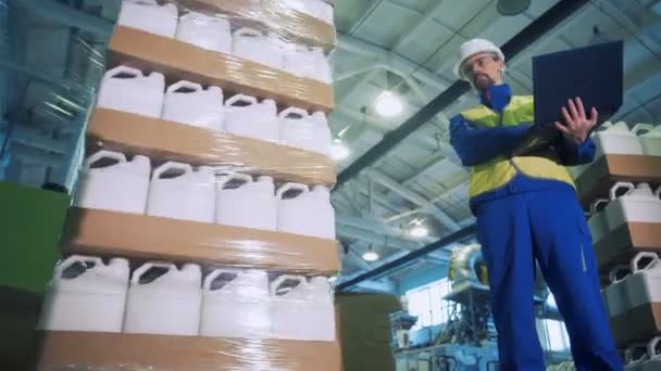 Plastové kanystry jsou stále zabalené do polyetylénu pod kontrolou pracovníků — Stock video