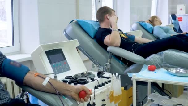 Volunteers donating blood in a modern center, medical machine in work. — Stock Video