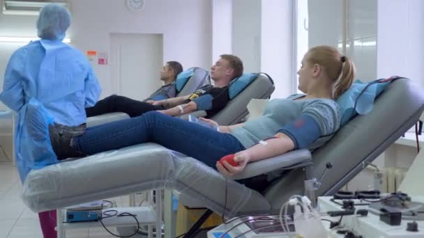 Un médico revisa donantes de sangre en un centro de donación, trabajo de caridad . — Vídeos de Stock
