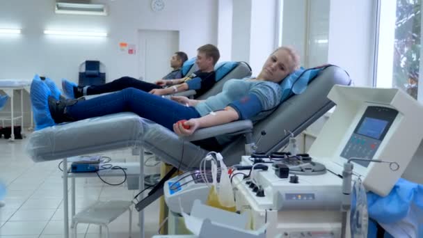 La gente dona sangre en el centro de transfusión, equipo médico . — Vídeos de Stock