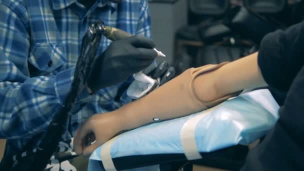 Gehandicapte persoon krijgen van een tattoo op een nephand op een tattoo salon. — Stockvideo