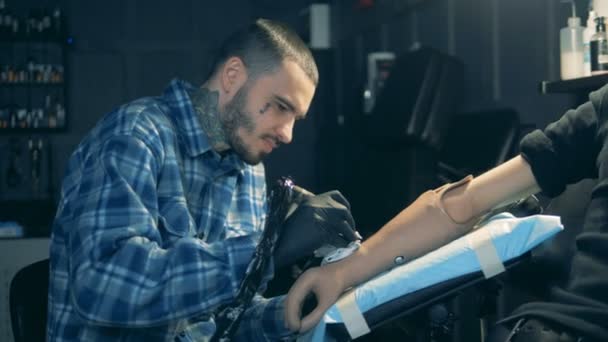Um homem tatuando em uma mão protética, equipamento biônico . — Vídeo de Stock