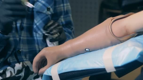 Gehandicapte man krijgen van een tattoo op een prothetische arm in een salon. — Stockvideo