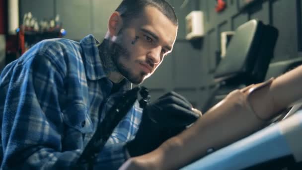 Un tatuador utiliza una máquina de agujas para dibujar en una prótesis de mano, brazo artificial . — Vídeos de Stock