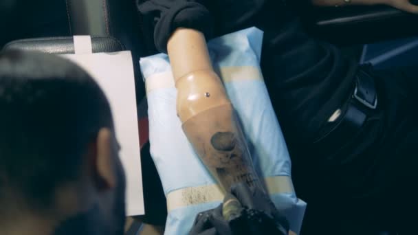 Mestre de tatuagem criando uma tatuagem em uma prótese de mão, braço artificial . — Vídeo de Stock