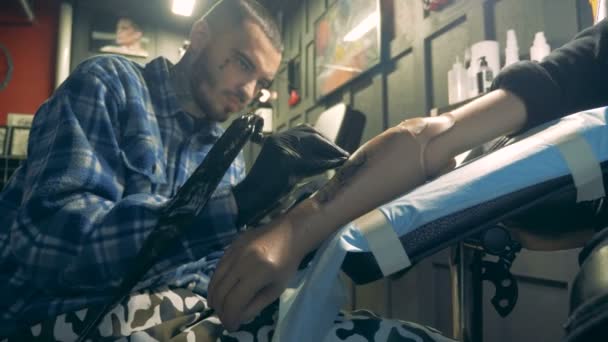 Young man works on a prosthetic hand, process of tattooing. — Stock Video