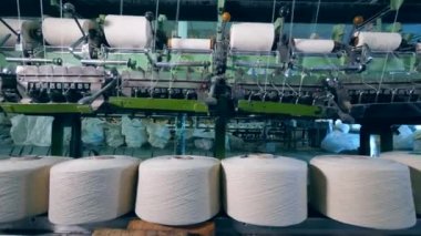 Dikiş biriktiricileri mekanik bir tekstil fabrikasında gevşemeden.