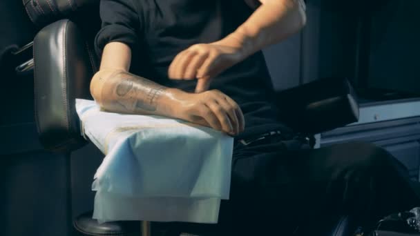 Persoon neemt een prothese hand met een tatoeage. — Stockvideo