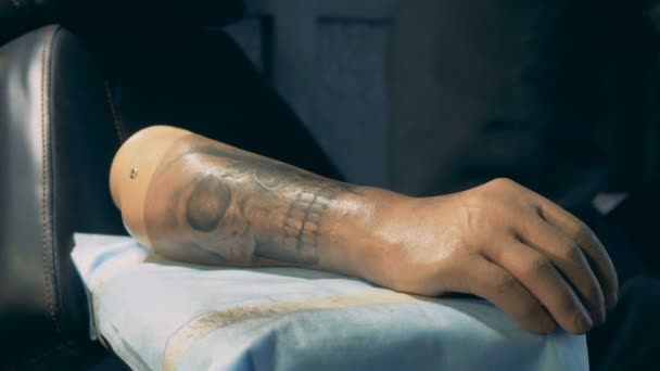 Funktionshindrad person sätter på en hand protes med tatueringar. — Stockvideo