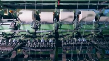 Beyaz iplik ile makaralar mekanik olarak unwound alıyorsanız. Konfeksiyon fabrikası üretim donanımları.