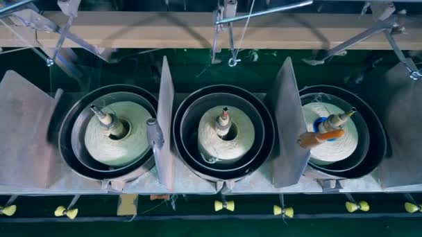 Mechanical unwinding of spools with white threads. Textile, knitting equipment at a production factory. — Stock Video