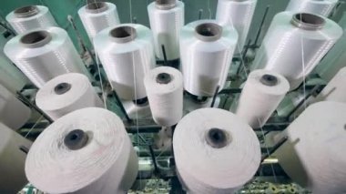 Dikiş makaraları ile bir tekstil fabrikasında beyaz iplik iplik.