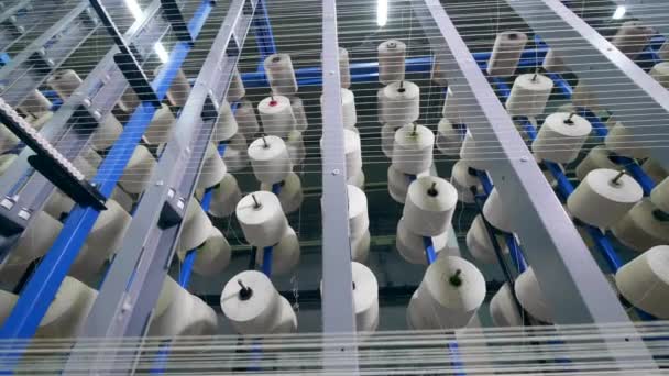 Top view of reels with white threads being static. Garment factory production equipment. — Stock Video