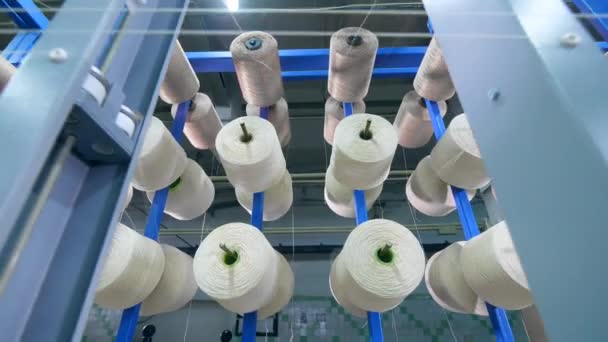 Garment factory production equipment. White threads are forming fabric while unwinding — Stock Video