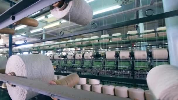 Vita trådar får mekaniskt omfördelas bland hjulen. Factory textilutrustning. — Stockvideo