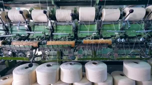 Nähspulen mit aufrollenden weißen Fäden. Produktionsanlagen für Bekleidungsfabriken. — Stockvideo