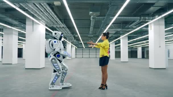 Höga robot är kommer till en tjej och omfamnar henne — Stockvideo