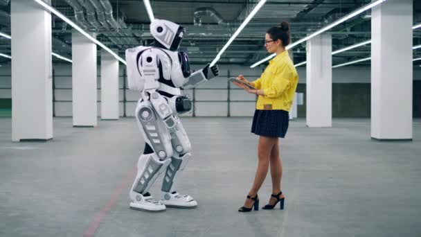 Jonge dame is het reguleren van instellingen van een mensachtige robot — Stockvideo