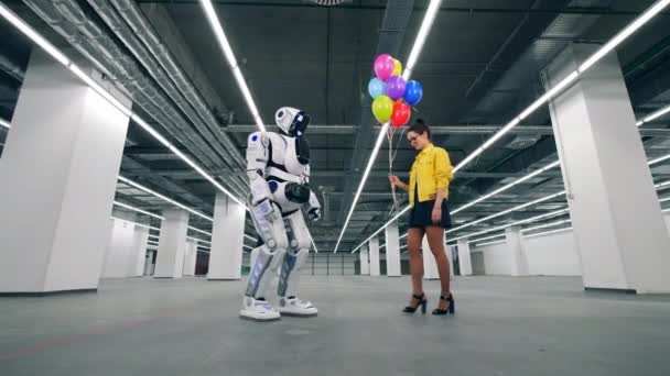 Bunte Luftballons werden einem Cyborg von einer Dame angeboten — Stockvideo