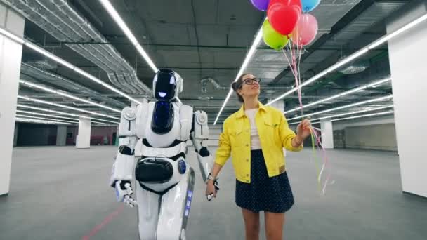 Tall robot loopt met een jonge vrouw met het praten — Stockvideo