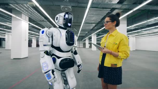 Young woman is coming and switching a cyborg on — Stock Video