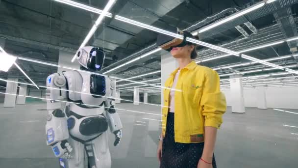Людський робот торкається руки жінки в VR-окулярах — стокове відео