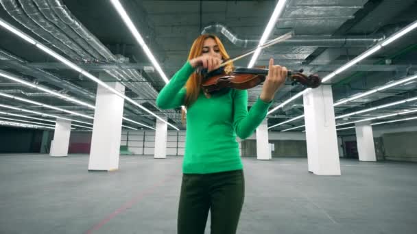 Lege opslagruimte met een vrouwelijke violist spelen van het instrument — Stockvideo