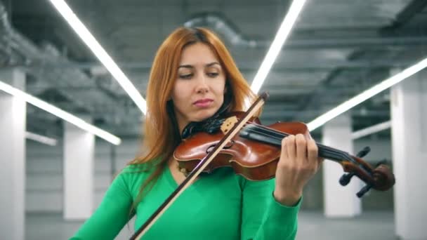 Вид спереди женщины с бронзовыми волосами, играющей на скрипке — стоковое видео