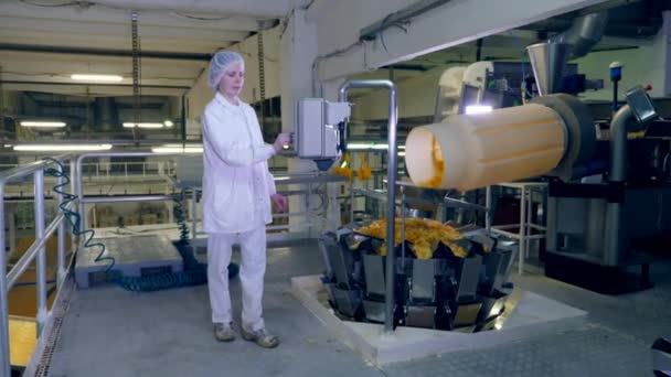 Persoon werkt met een machine fabriek, controle op een transportband met chips. — Stockvideo