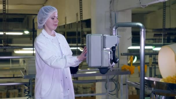 Mujer joven trabaja con equipo de fábrica en una instalación de producción de alimentos . — Vídeos de Stock