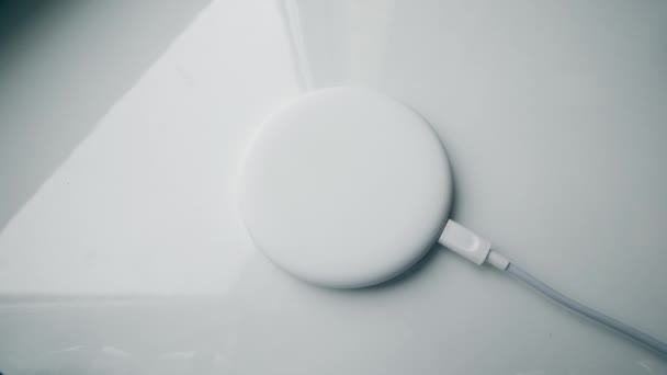 L'homme commence à recharger son téléphone, le plaçant sur un tampon de charge sans fil . — Video