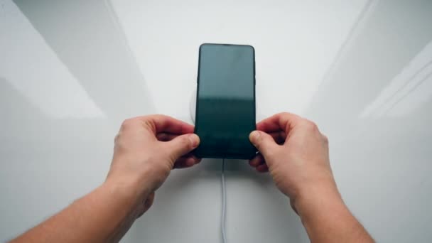 Persoon plaatst een telefoon op een rekening brengen pad voor draadloos opladen. Draadloze technologie concept. — Stockvideo