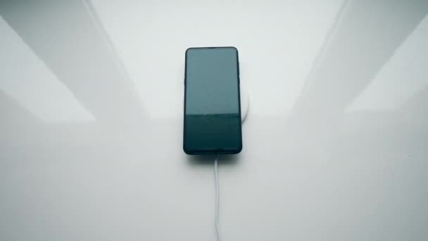 Un homme recharge son téléphone, le mettant sur un chargeur sans fil. Concept de technologie sans fil .