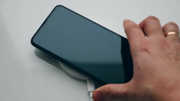 Draadloze oplader werkt met één telefoon, geplaatst op het. Draadloos opladen concept. — Stockvideo