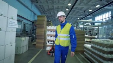 Erkek işçi plastik kaplar kutularıyla taşıyor