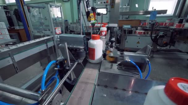 La máquina de cinta está procesando contenedores de plástico — Vídeo de stock