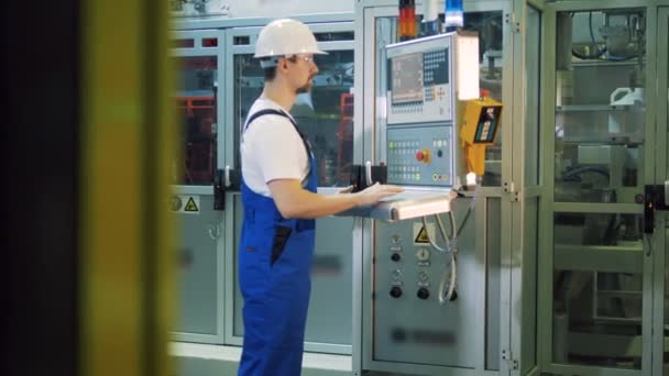 Eenheid van de fabriek met een mannelijke specialist die een control panel — Stockvideo