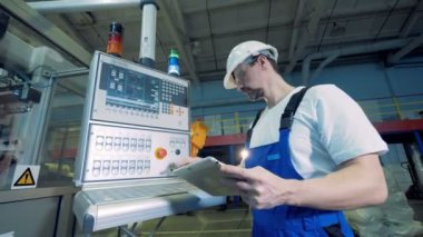 Fabrikada çalışan bir tablet ve izleme konsolu çalışıyor