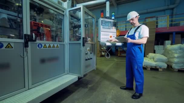 Engenheiro masculino está gerenciando um painel de controle em uma unidade de fábrica — Vídeo de Stock