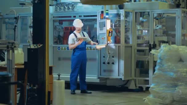 Instalaciones de la fábrica con un experto masculino que opera un tablero de control — Vídeo de stock