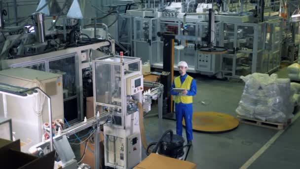 Peralatan produksi plastik sedang diamati oleh seorang profesional laki-laki — Stok Video