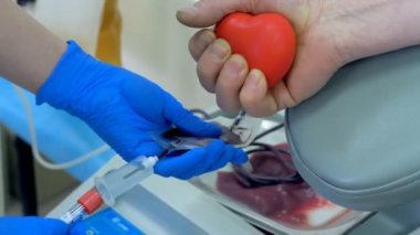 Bir hemşire kan pompalama makine bir hasta bir klinikte kan bağışladı ayarlar.