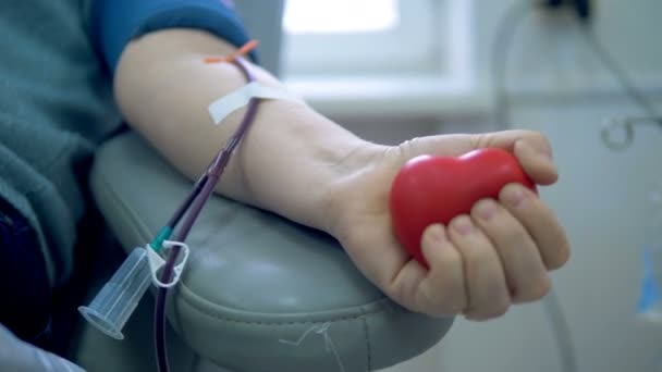 Людина стискає м'яч під час здачі крові в центрі переливання . — стокове відео