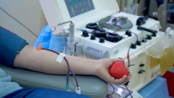 Patiënt doneert bloed door buizen en spuiten in een moderne transfusie center. — Stockvideo