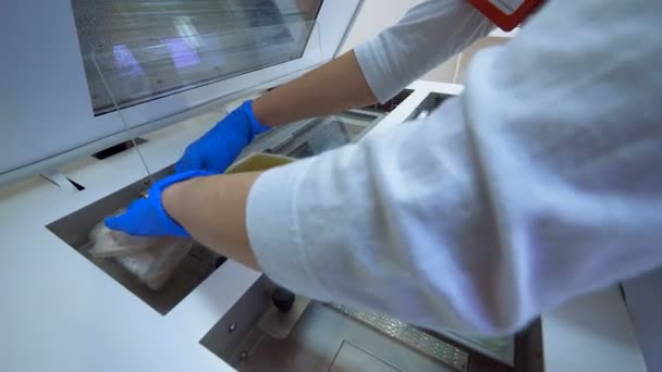 Klinikmitarbeiterin legt Säcke mit Plasma auf Labormaschine. — Stockvideo
