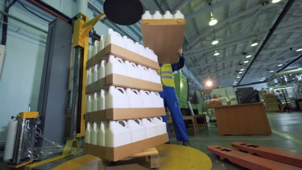 Cajas de cartón con contenedores de plástico se están apilando por cargador masculino — Vídeos de Stock