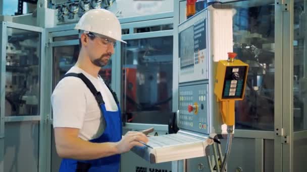 L'esperto maschio gestisce un pannello di controllo nei locali della fabbrica — Video Stock