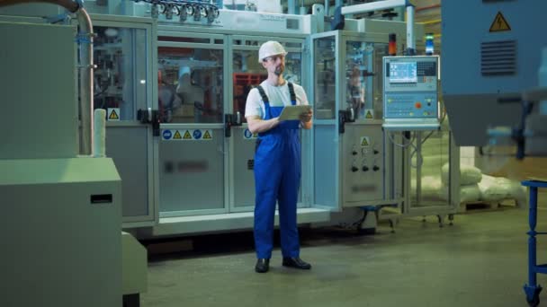 Il dipendente della fabbrica sta osservando il processo di produzione in una fabbrica — Video Stock